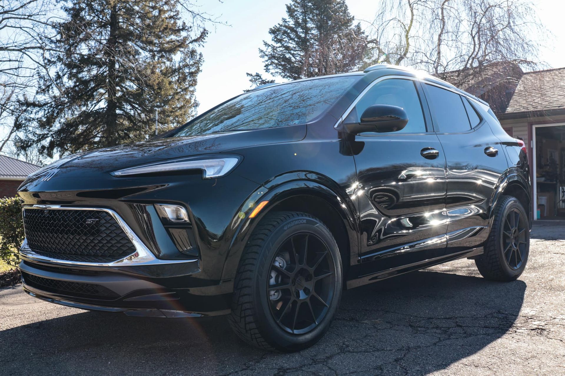 a black suv is parked in front of a garage .