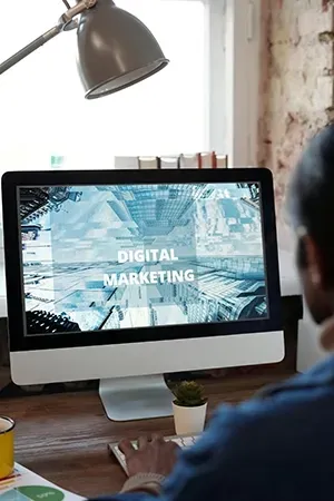 Person at desk viewing “Digital Marketing” on desktop computer in a modern office