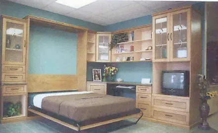 Bedroom with wooden furniture, a bed, built-in shelves, and a TV in a cozy beige and teal interior.