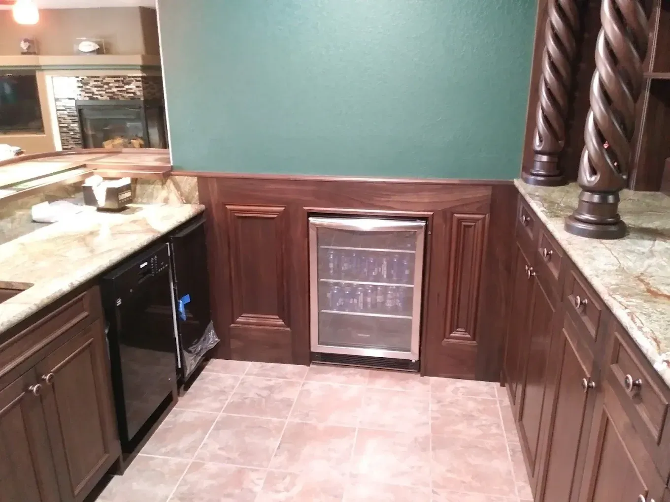 Kitchen bar area with brown cabinets, granite counters, tile floor, and a wine cooler built into the wall.