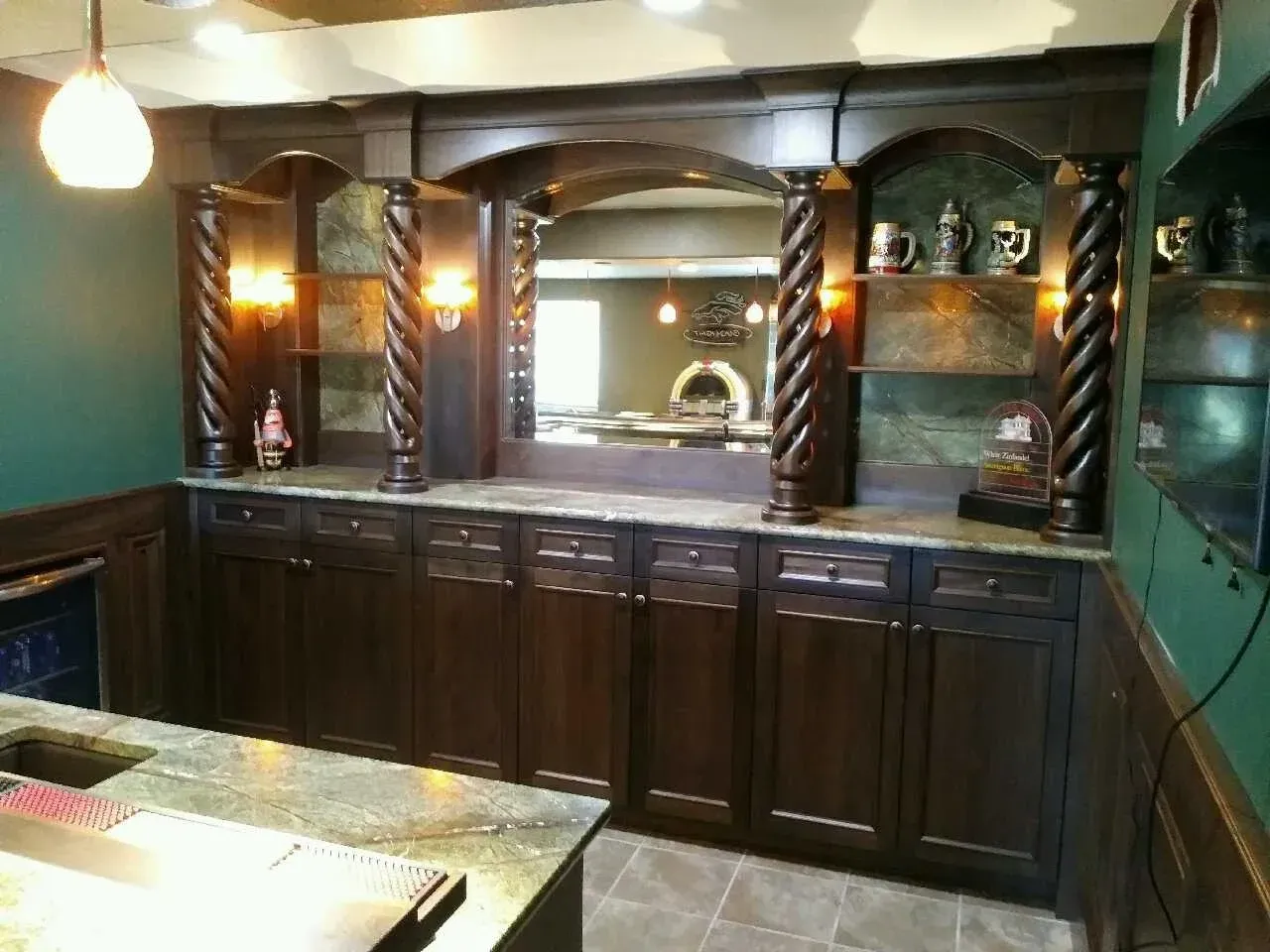 Dark wood bar cabinet with mirror, shelves, and warm lighting in a cozy interior room