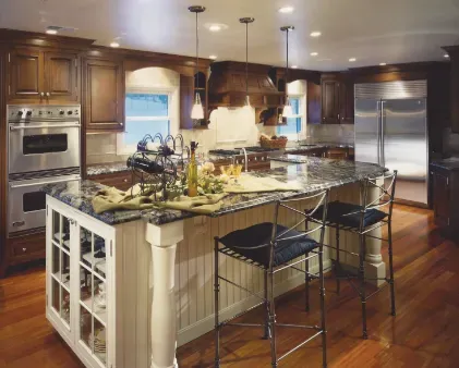 Modern kitchen with large island, stainless steel appliances, and warm wood cabinets