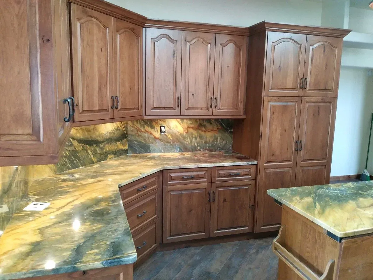 Custom kitchen with light wood cabinets, green-yellow stone countertops, and tiled backsplash.