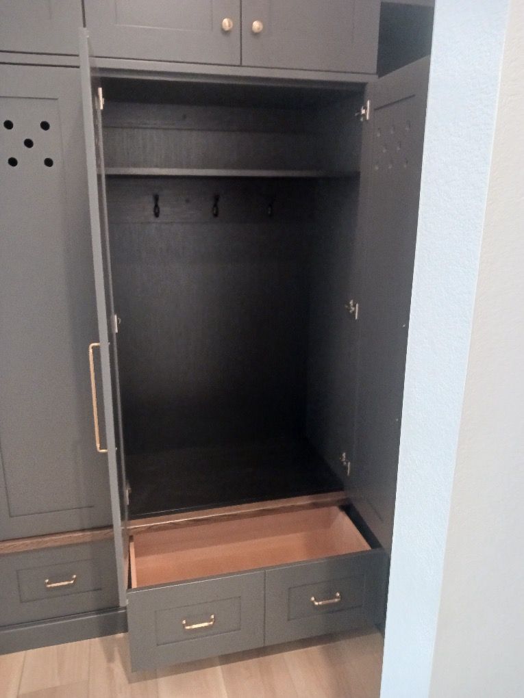 Open dark gray wardrobe cabinet with shelves and a bottom drawer partially pulled out