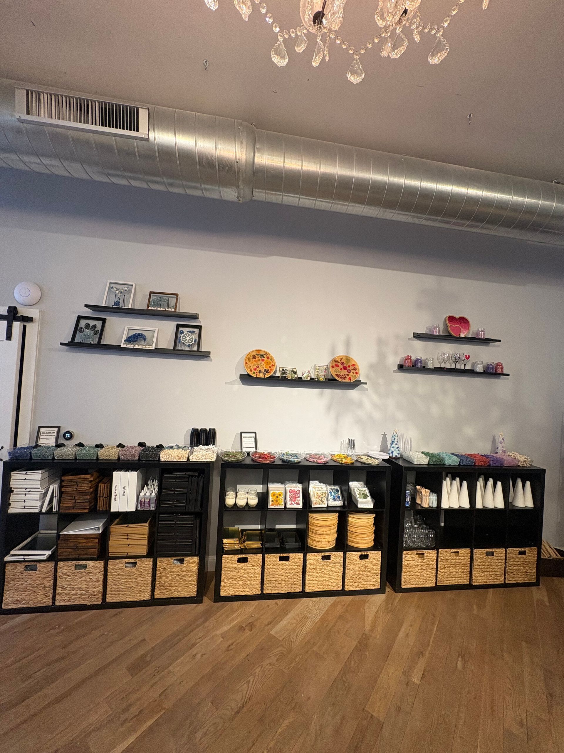 Retail display of baskets, shelves, and small decor items against a white wall in a store interior