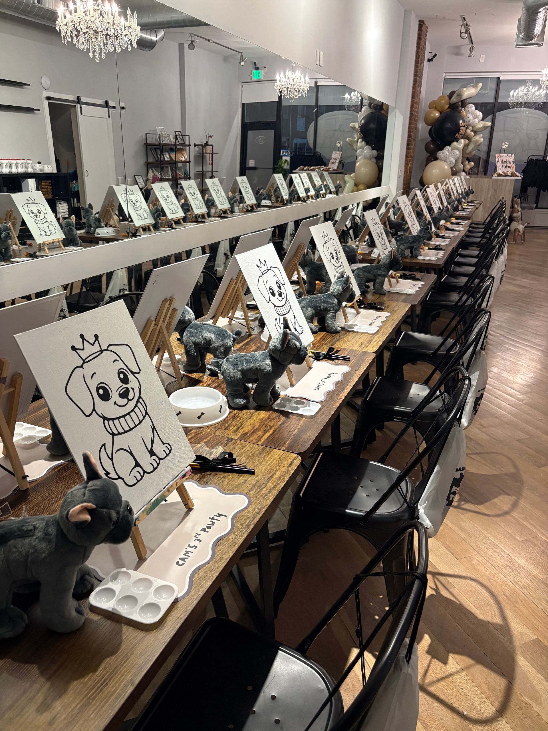 Long art table with numbered sketchboards and supplies in a bright studio room