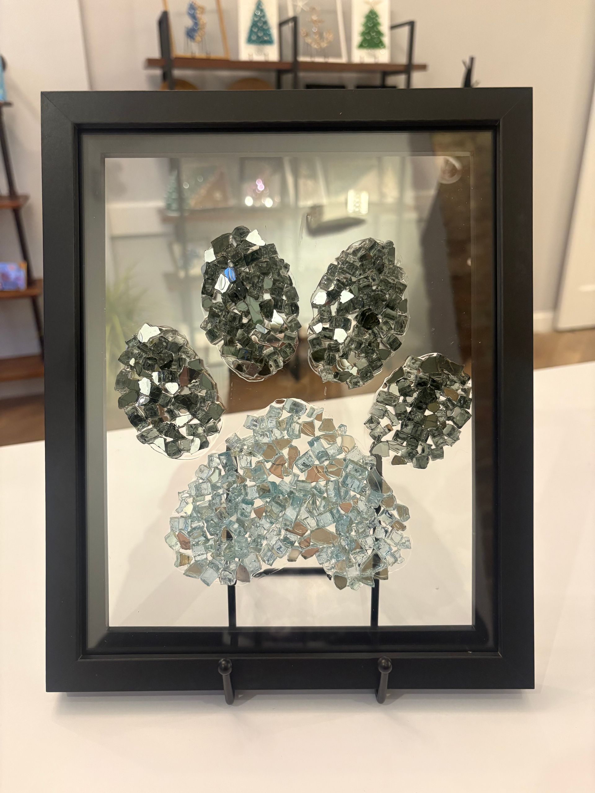 Framed paw print made of crystals on a stand, with silver and pale blue stones