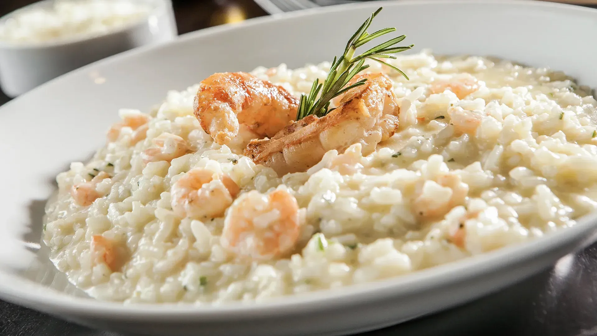 Um prato branco coberto com camarão e arroz sobre uma mesa.