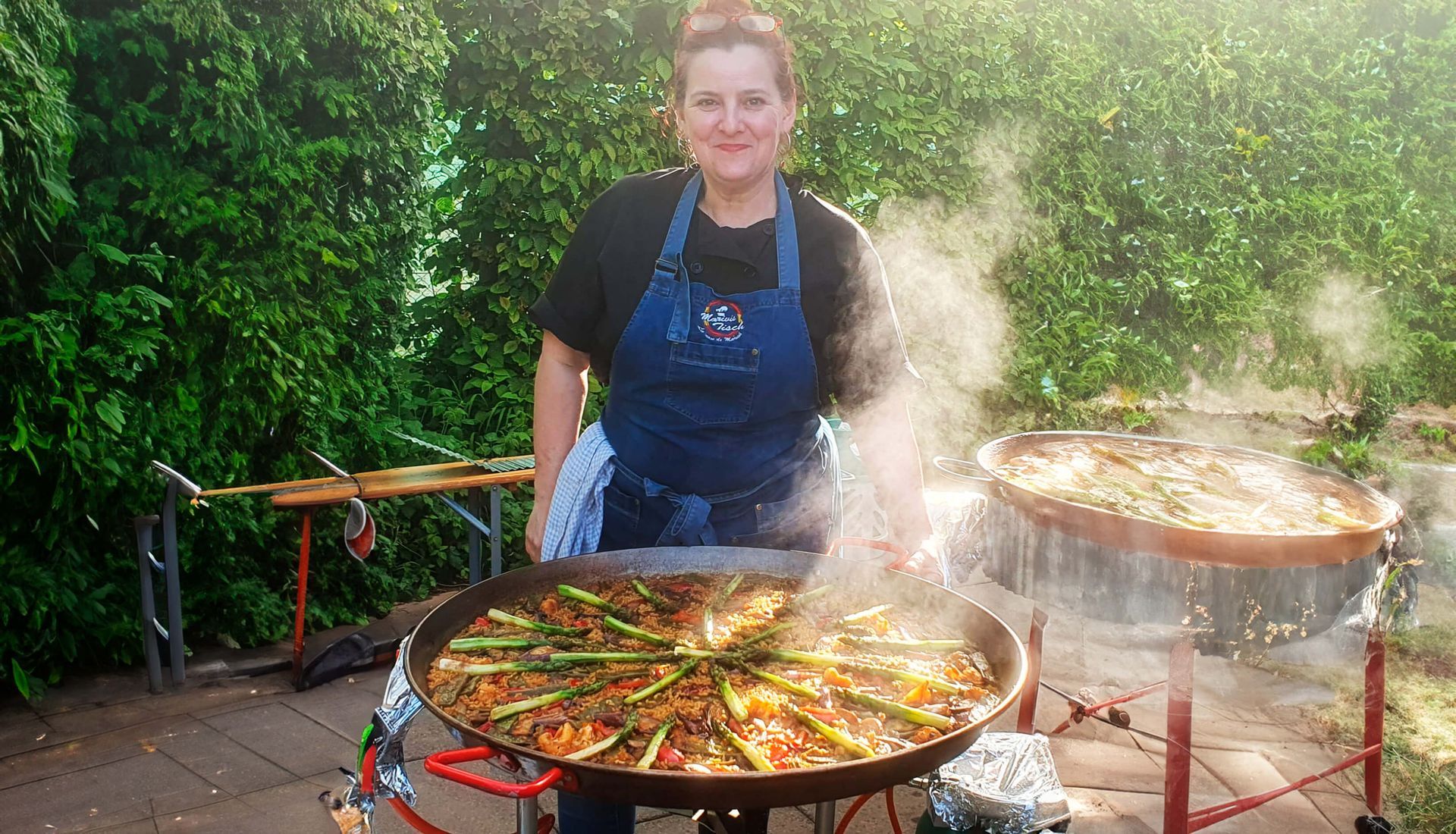 Mariví está parada frente a una gran olla de comida en Suiza