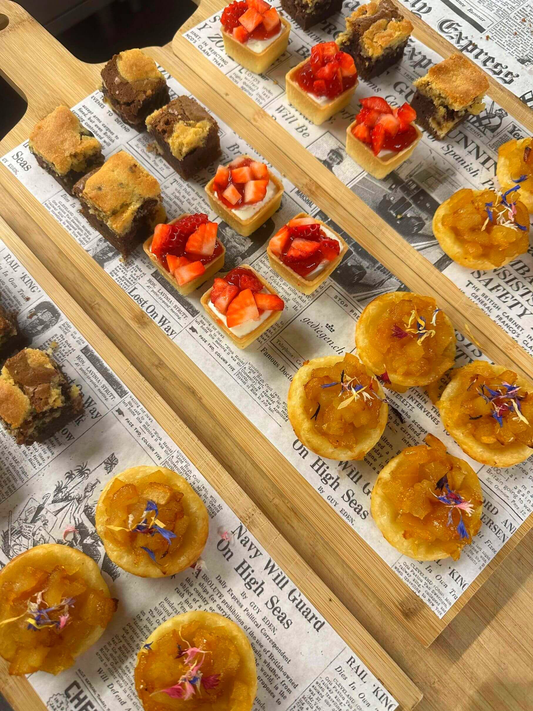 Una tabla de cortar de madera cubierta con una variedad de postres.