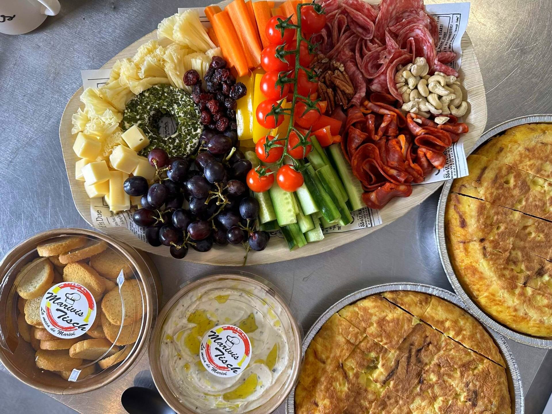 Un plato de comida con verduras, carne, queso y galletas en una mesa.
