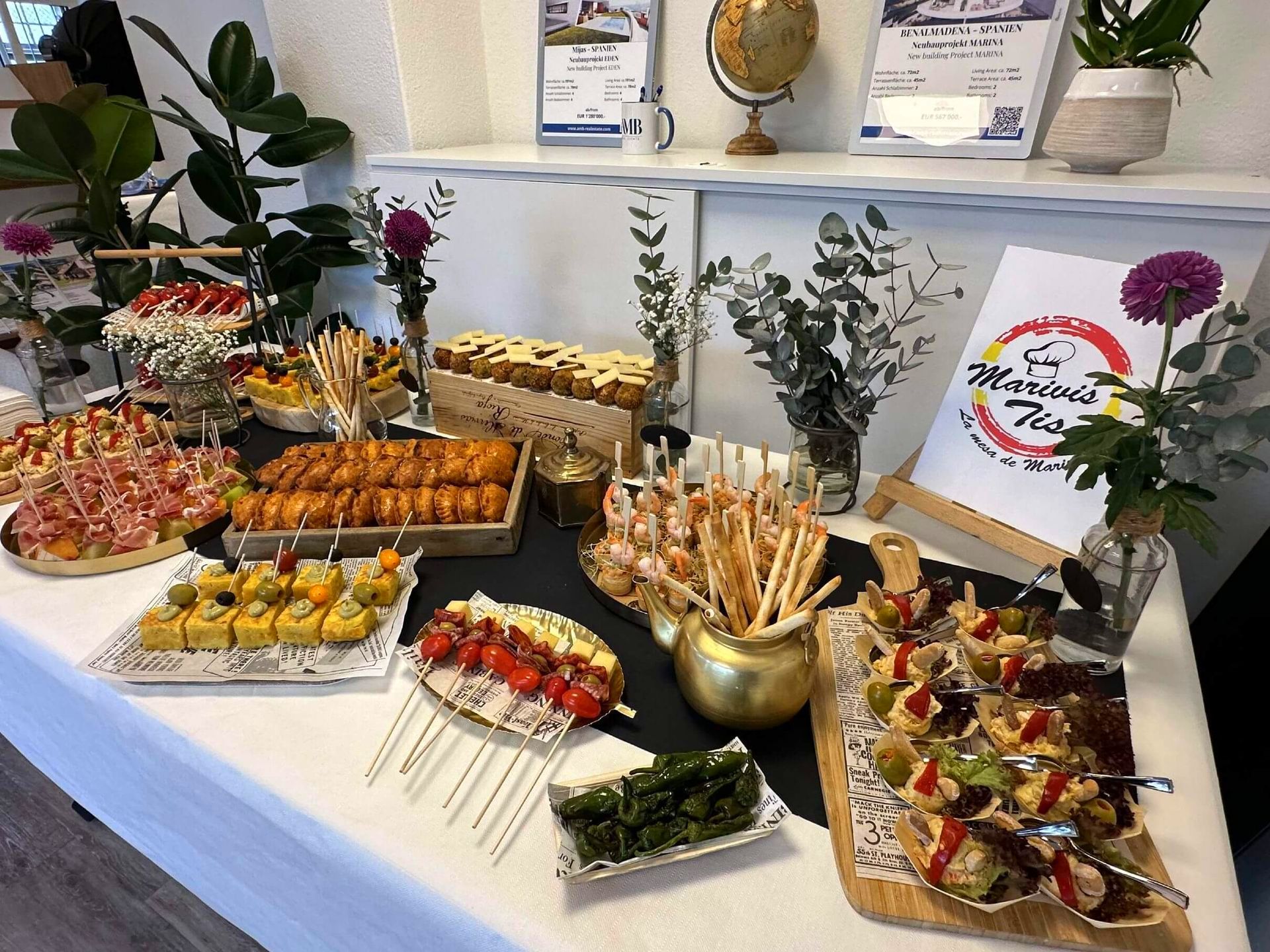 Una mesa cubierta con una variedad de alimentos y flores.