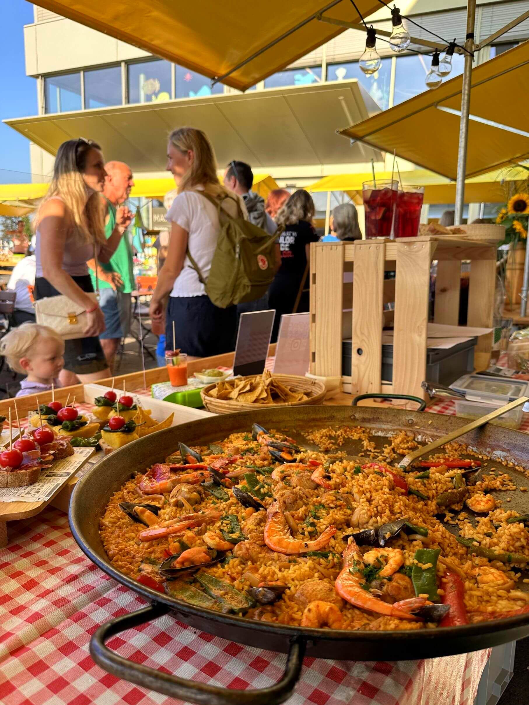 Una gran sartén con paella reposa sobre un mantel a cuadros en Suiza
