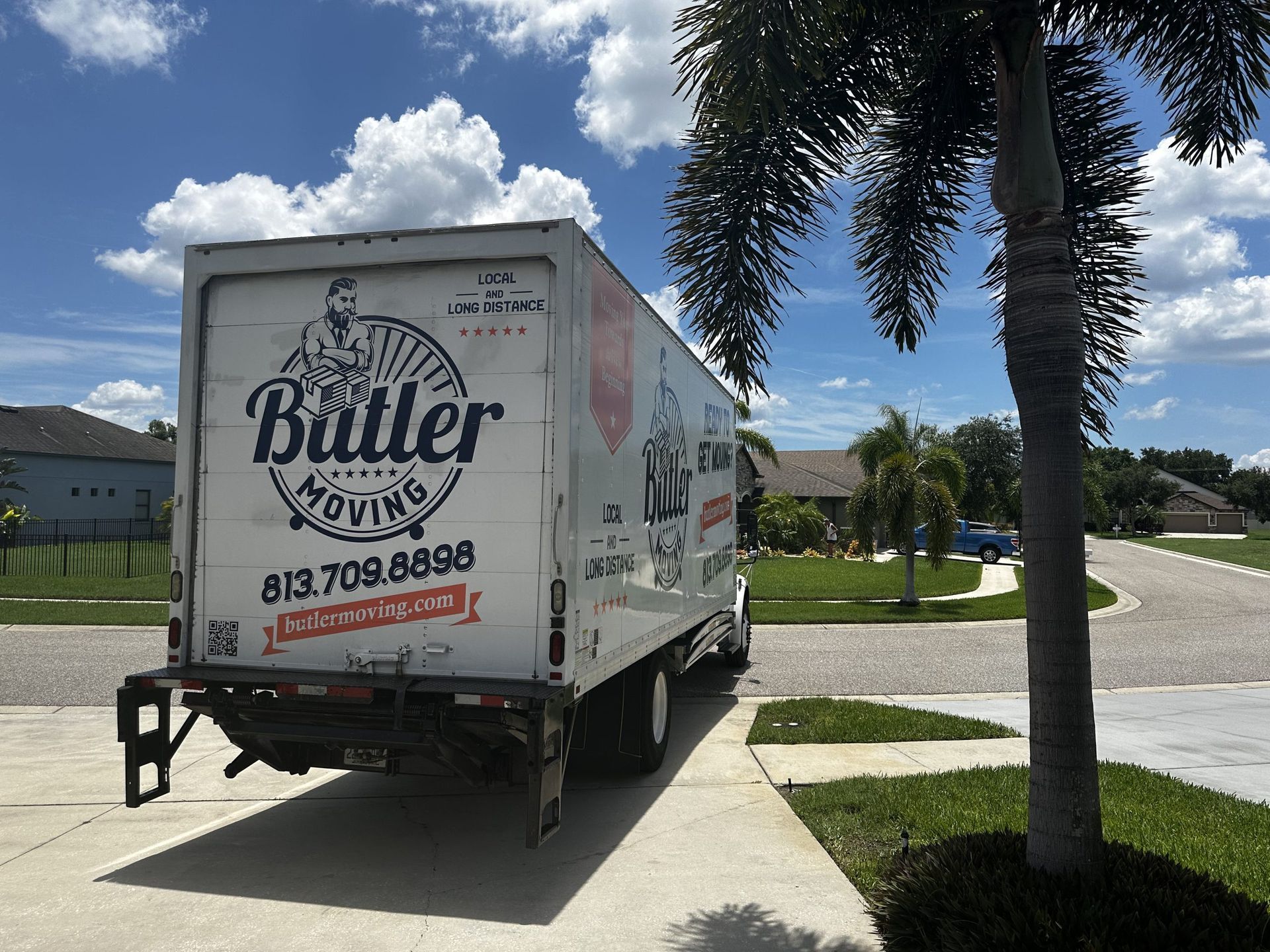 A butler moving truck is parked on the side of the road