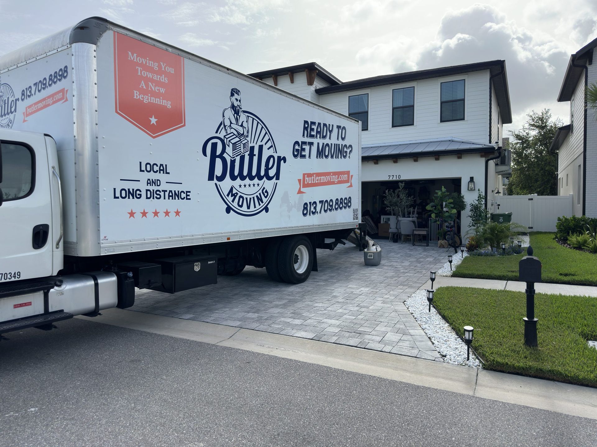 Two moving trucks are parked in front of a house.