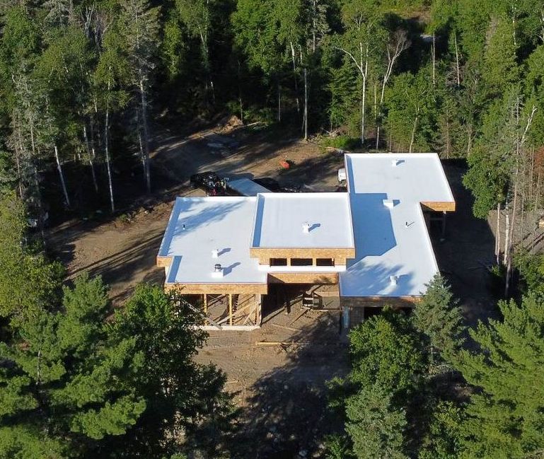 Une vue aérienne d'une maison au milieu d'une forêt.