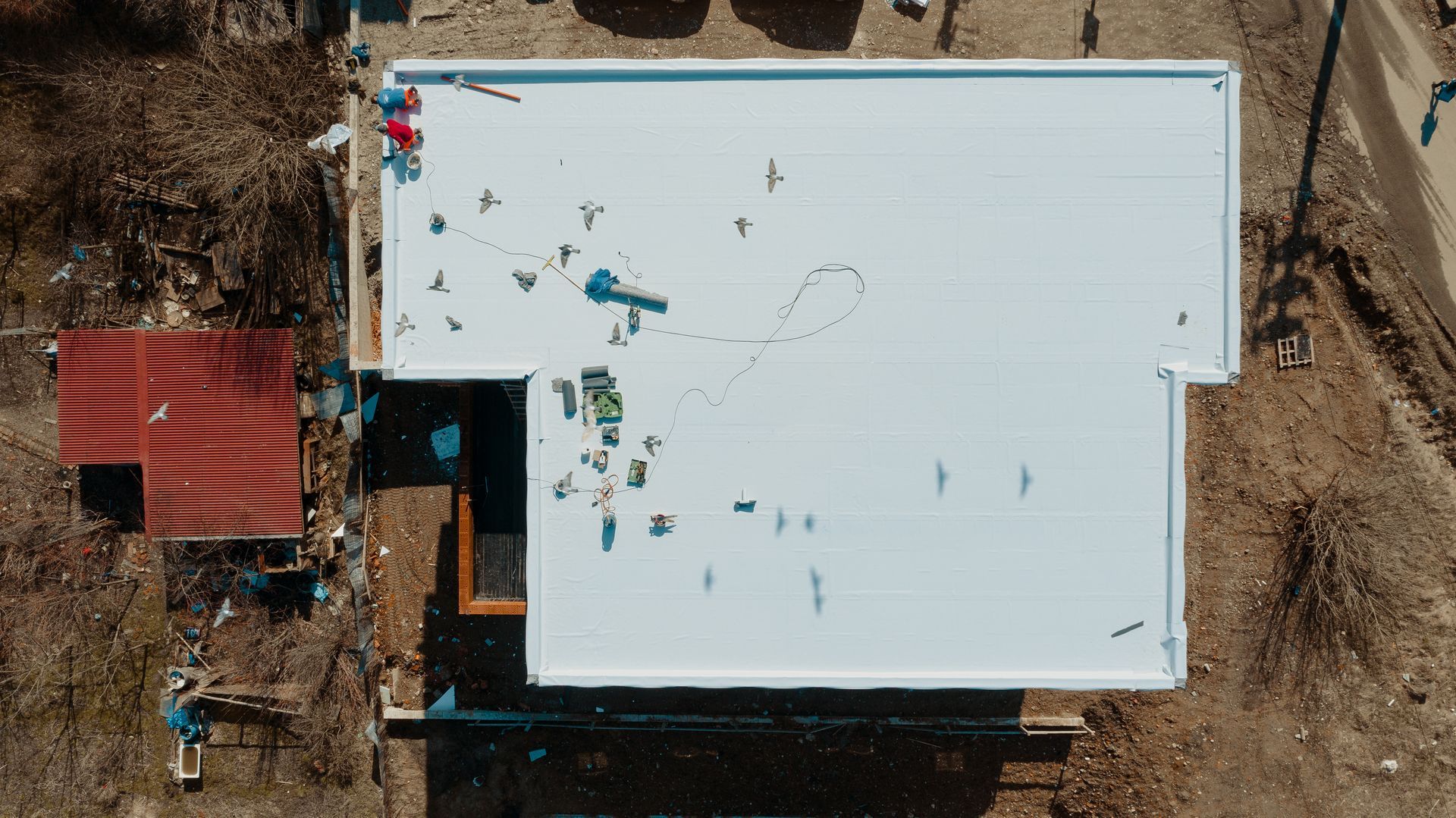 Une vue aérienne d'une maison en construction avec un toit blanc.
