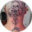 Un homme avec un tatouage de crâne sur la tête et le cou.