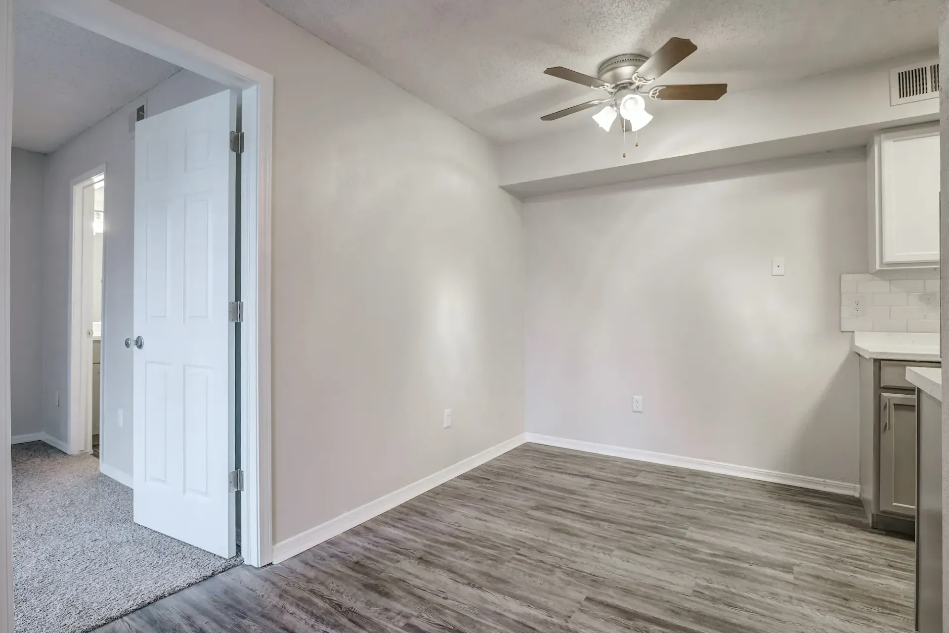 An empty bedroom with a window and a carpeted floor.