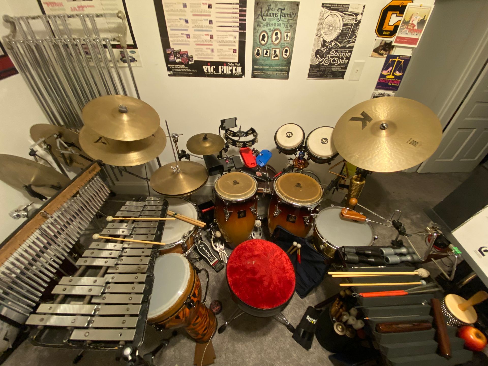 Home music studio with a drum kit, vibraphone, congas, and cymbals arranged in a small room
