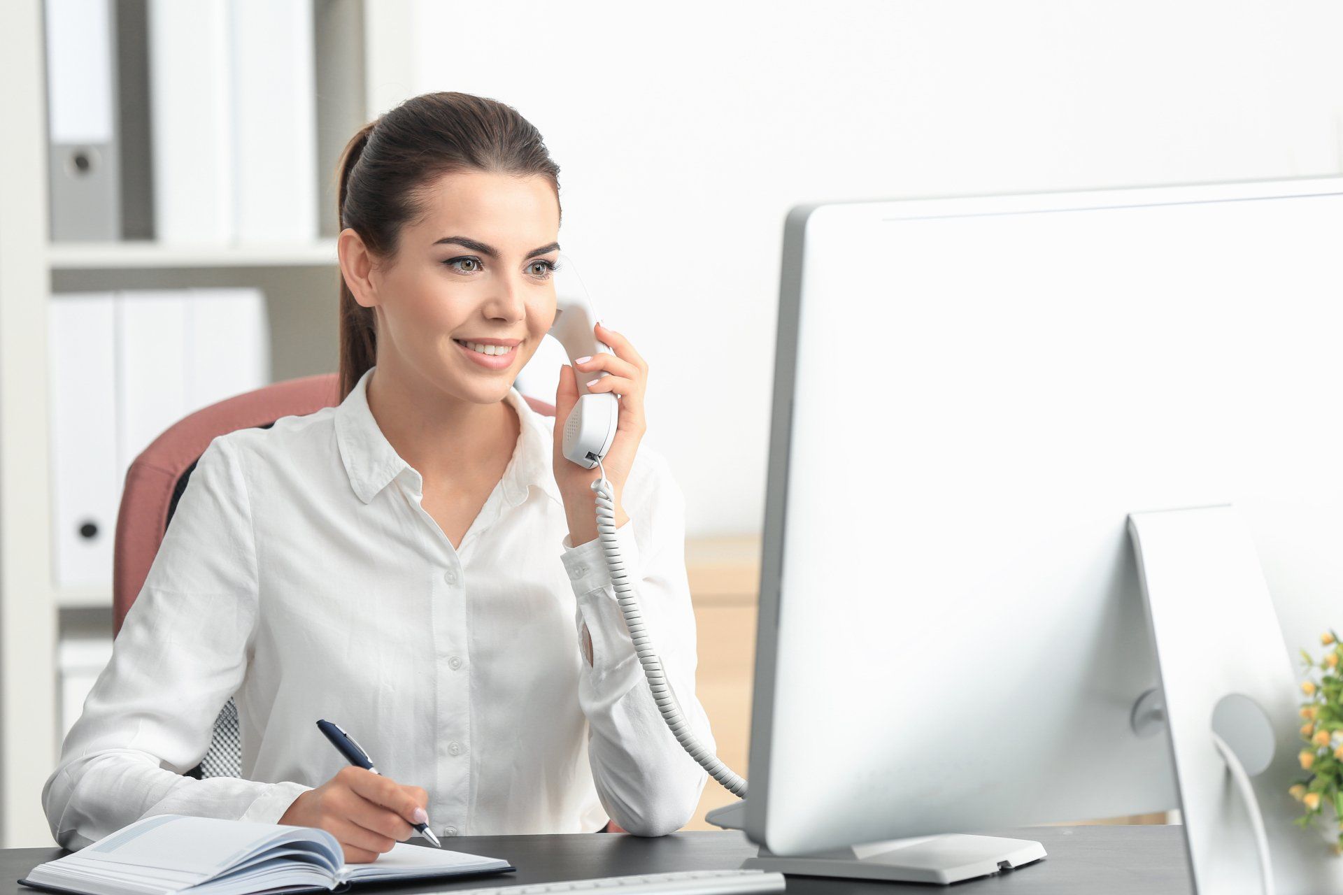 Young female talking on phone in office