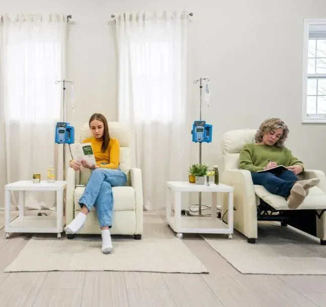 Two patients relaxing during IV therapy sessions at a clinic
