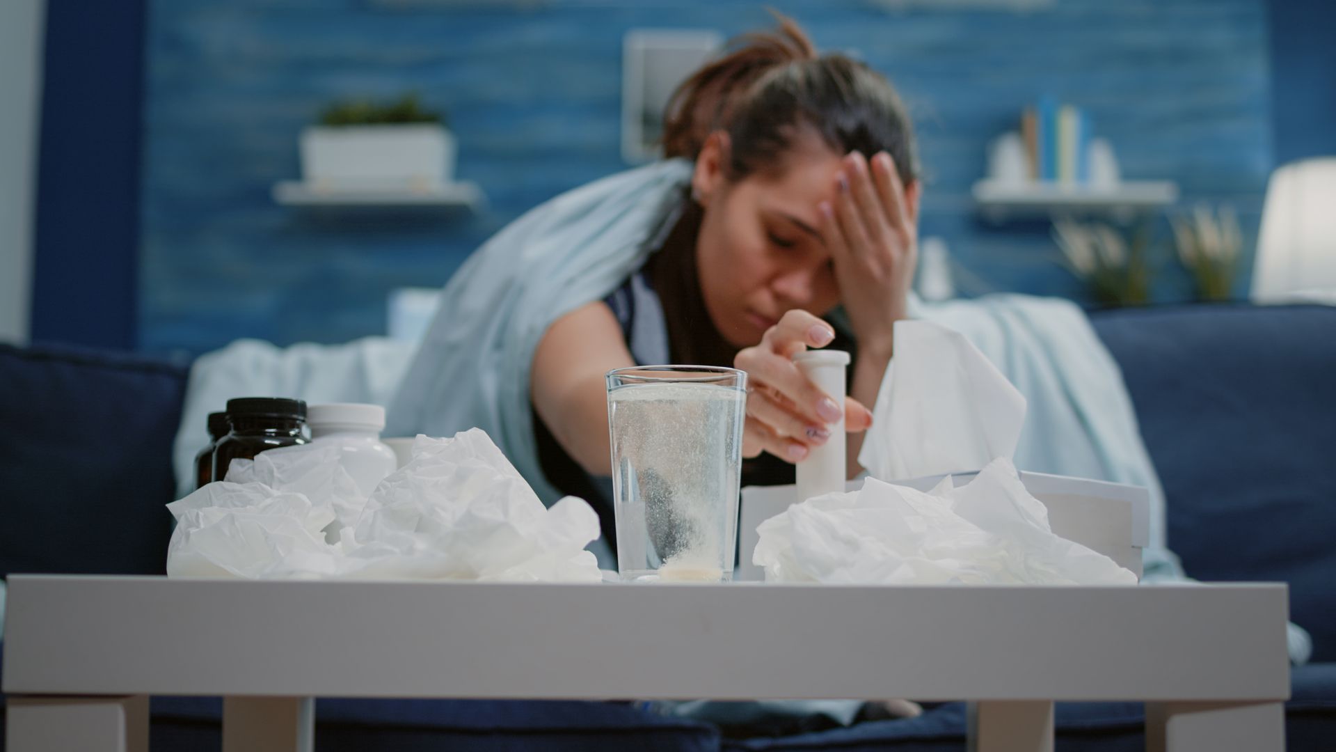 Woman dropping an effervescent vitamin tablet into water