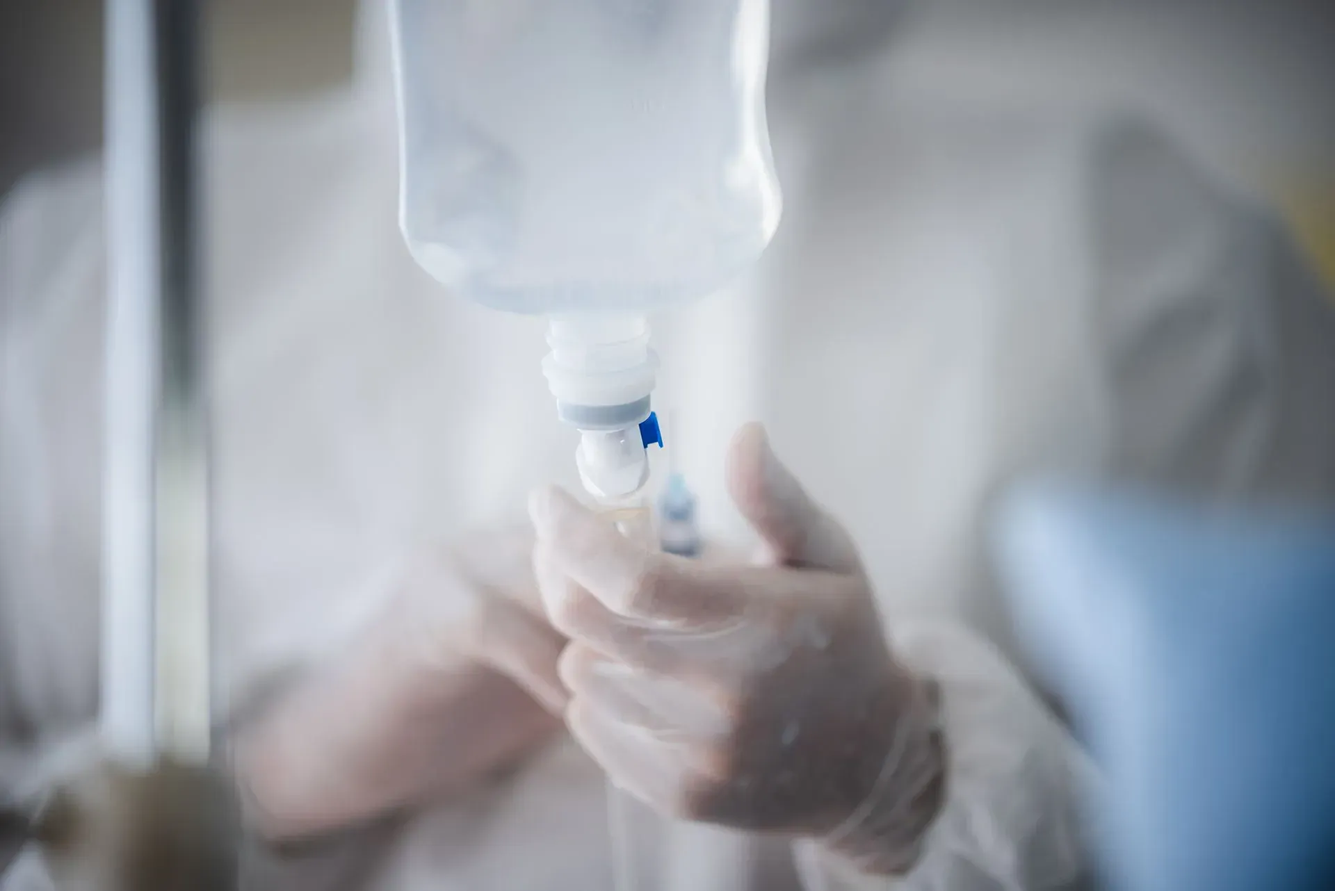Nurse setting up an IV drip bag for treatment