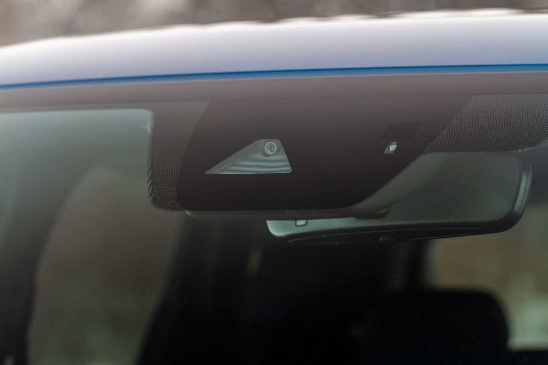 Blue car interior: sensors behind rearview mirror.