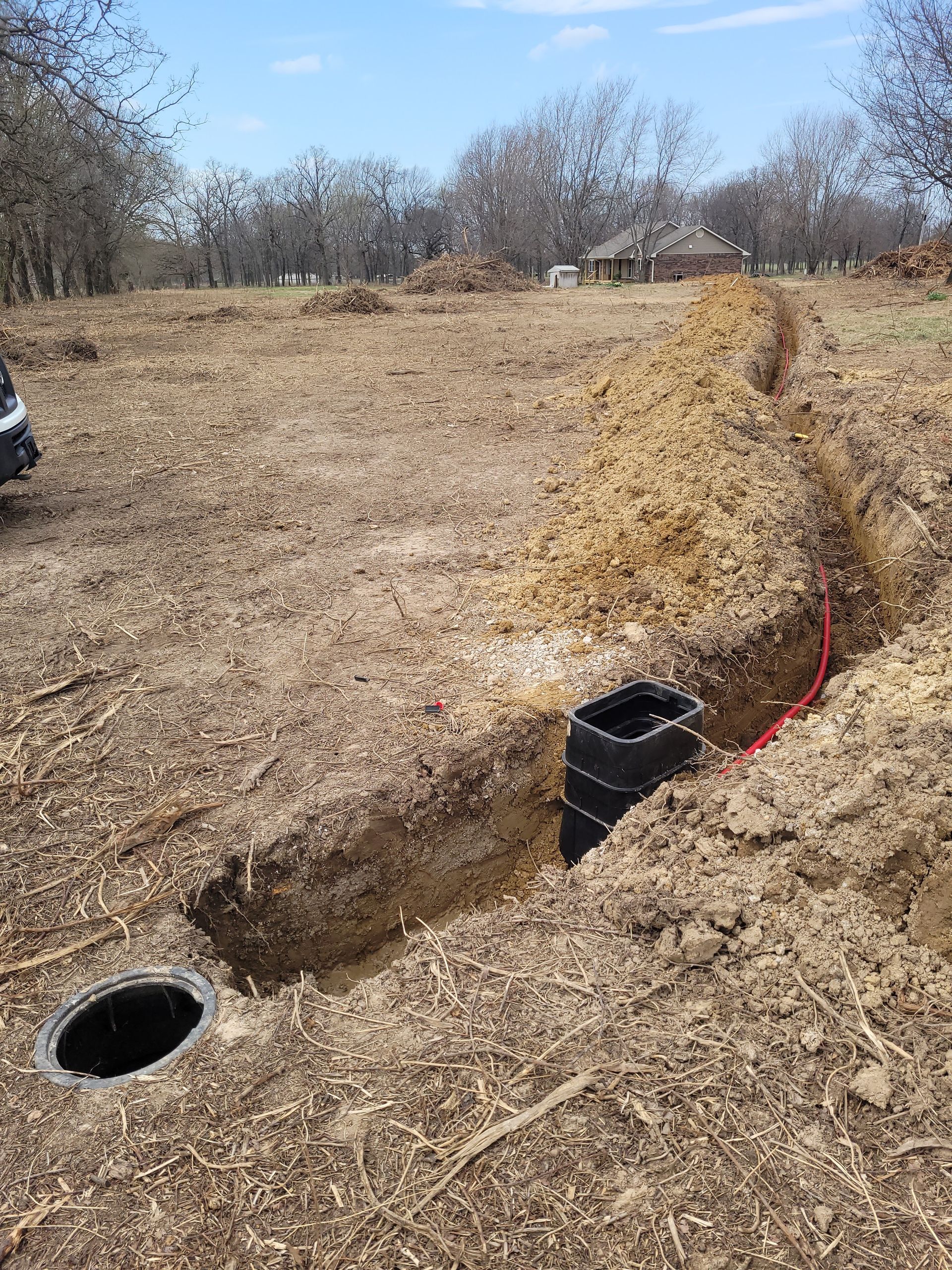 There is a hole in the ground in the middle of a field.