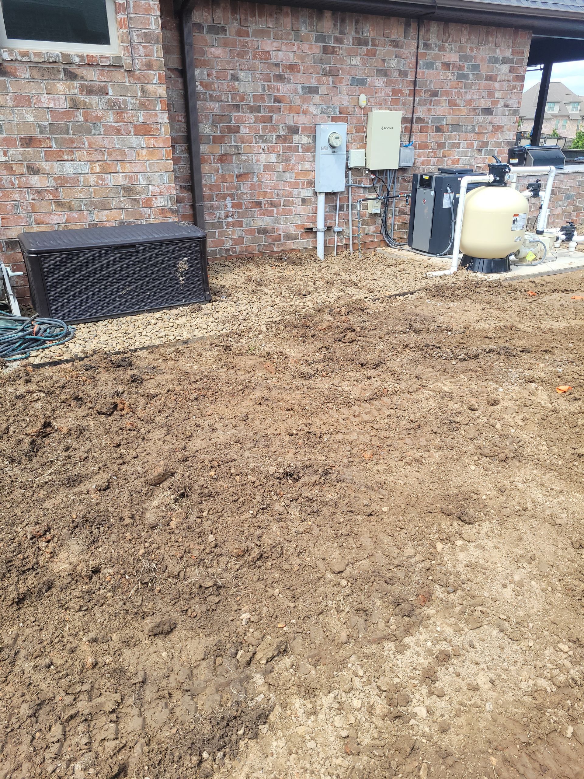 A pile of dirt is sitting in front of a brick building.