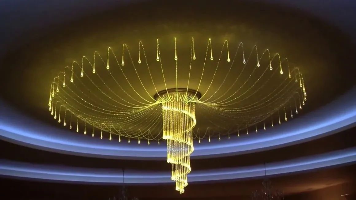 A large chandelier is hanging from the ceiling in a dark room.