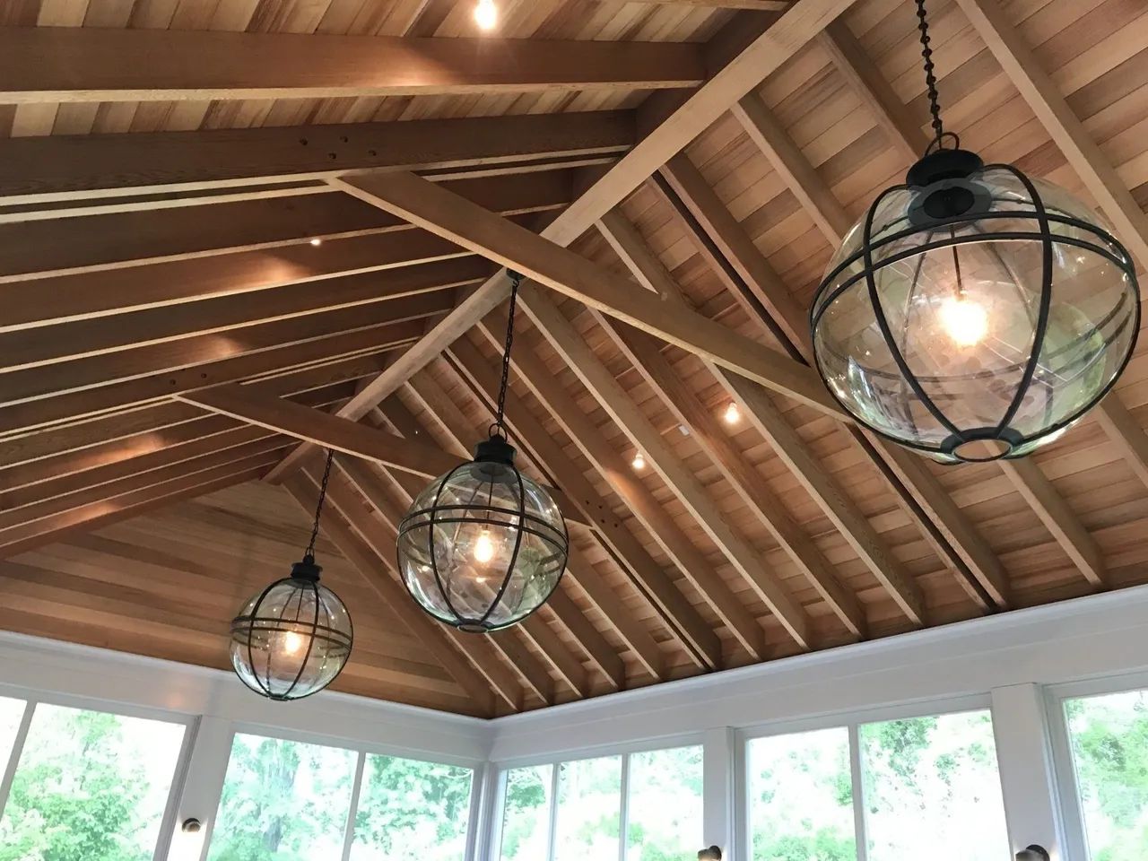 A room with a wooden ceiling and lanterns hanging from it