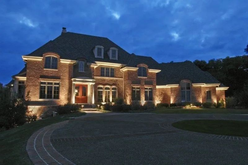 A large brick house is lit up at night