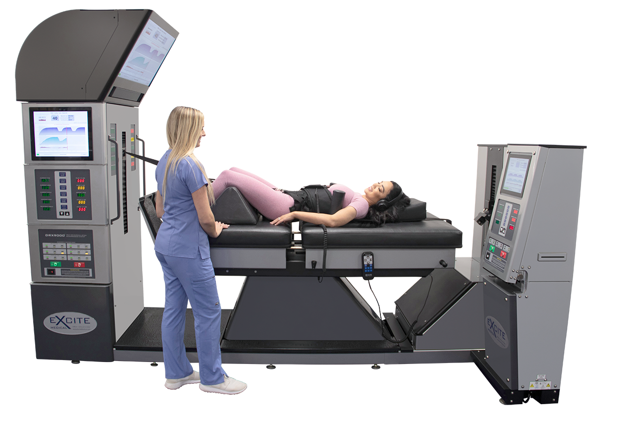 A person in scrubs assists a patient lying on a spinal decompression therapy table in a medical setting.