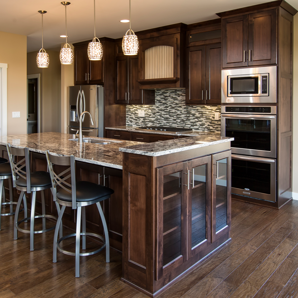 Kitchen with a dark wood island and cabinets, stainless steel appliances, and pendant lights.