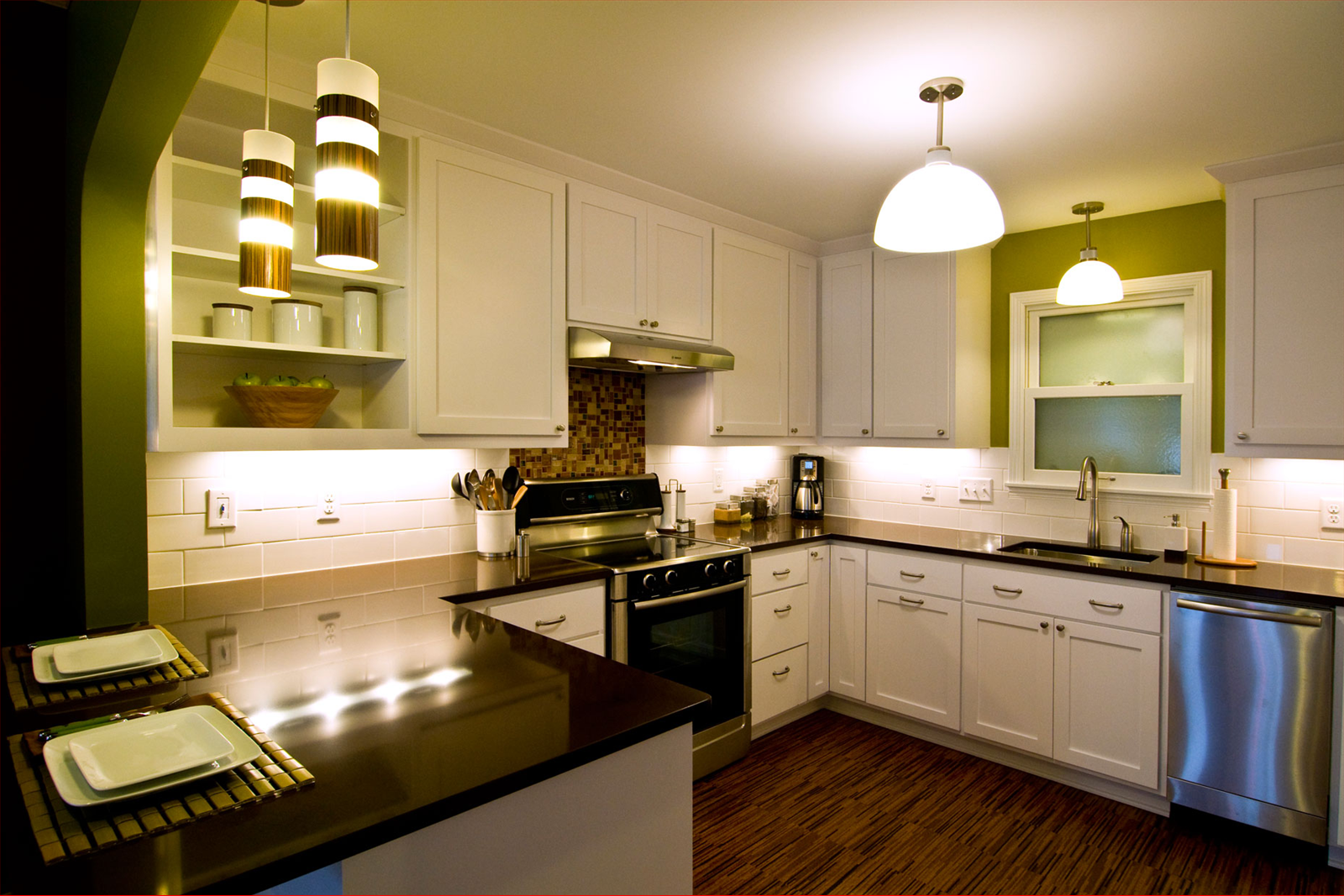 Modern kitchen with white cabinets, dark countertops, and stainless steel appliances.