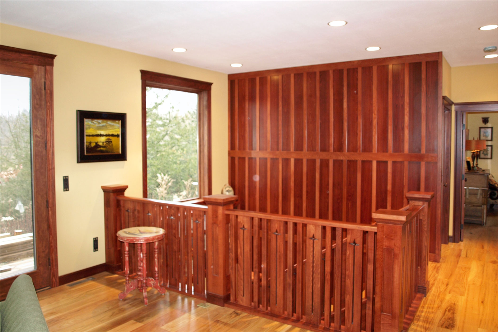 Interior with wood railing, walls, and trim, overlooking a view from a window.