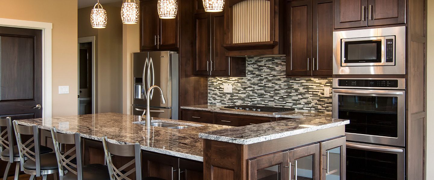 Kitchen with dark brown cabinets, granite countertops, and stainless steel appliances.