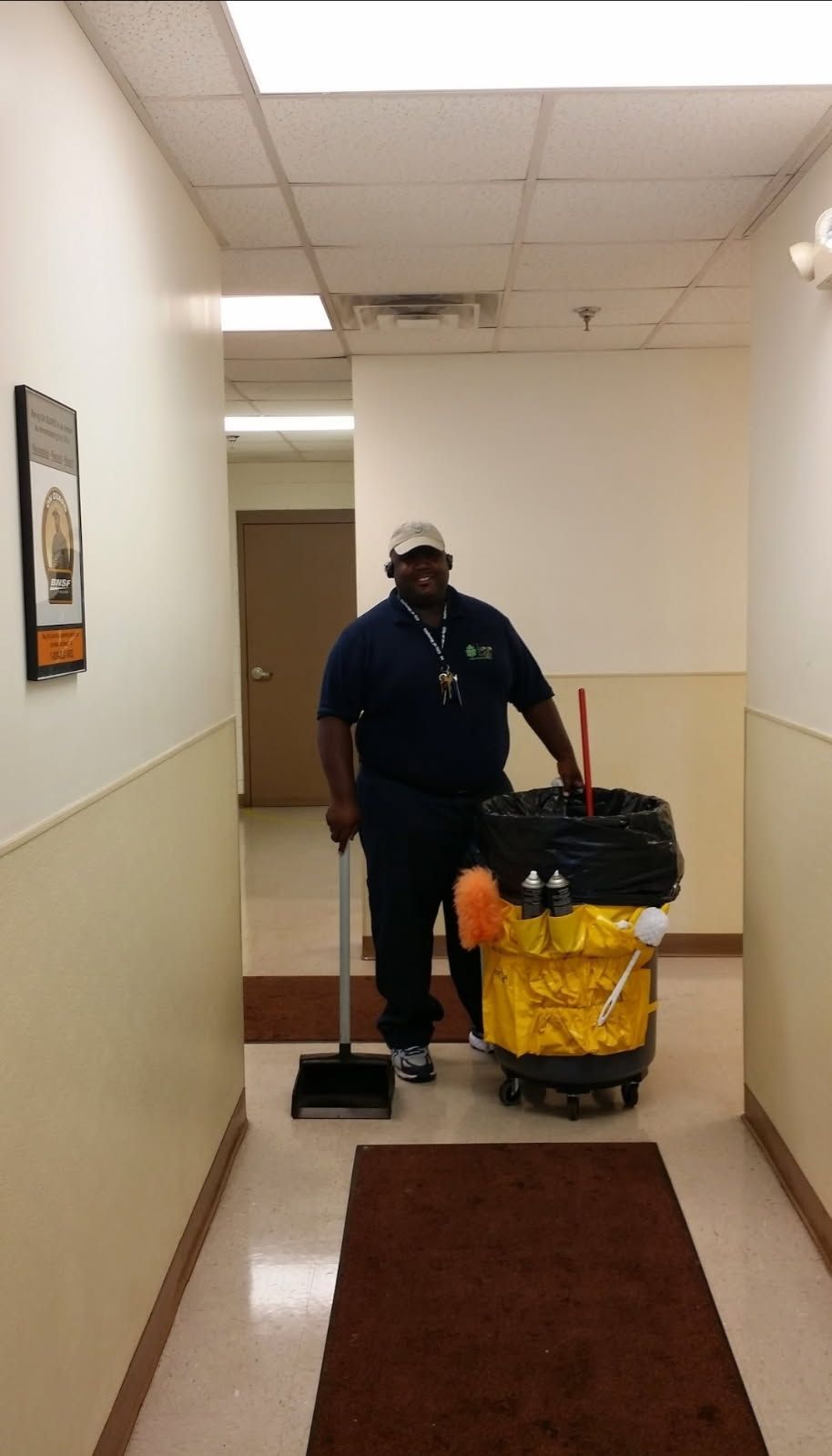 A man is cleaning a hallway with a mop and bucket.