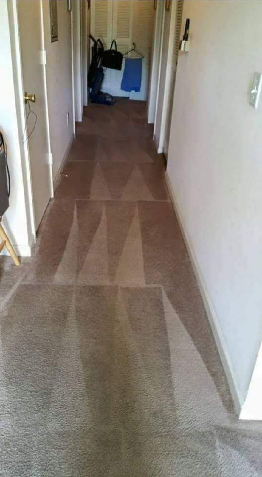 A long hallway with a carpeted floor in a house.