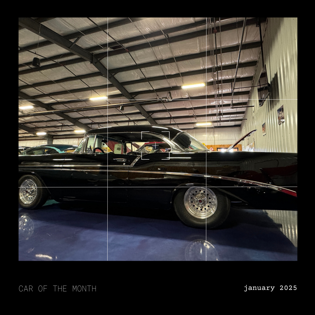 Black classic car on display inside a garage, January 2023.