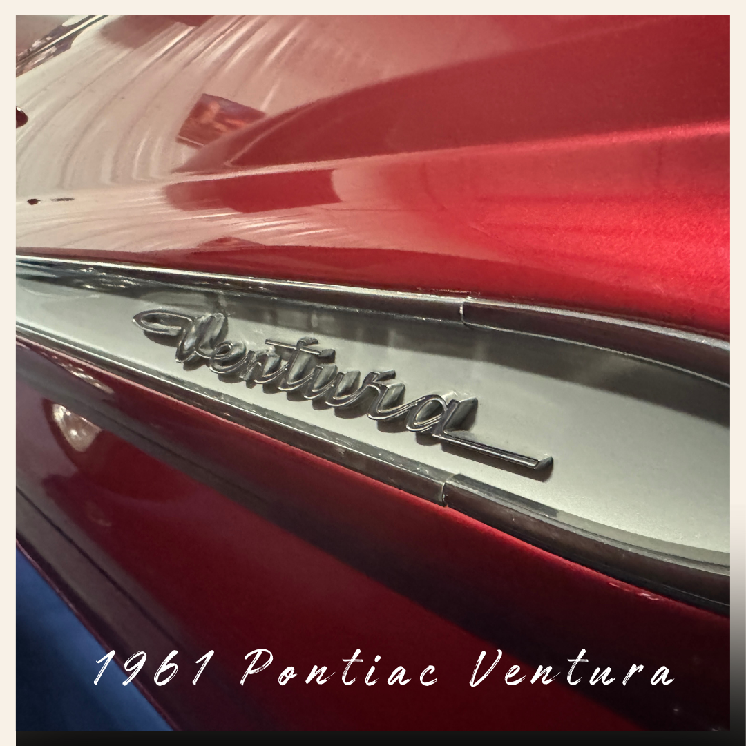 Close-up of a red 1961 Pontiac Ventura car emblem.