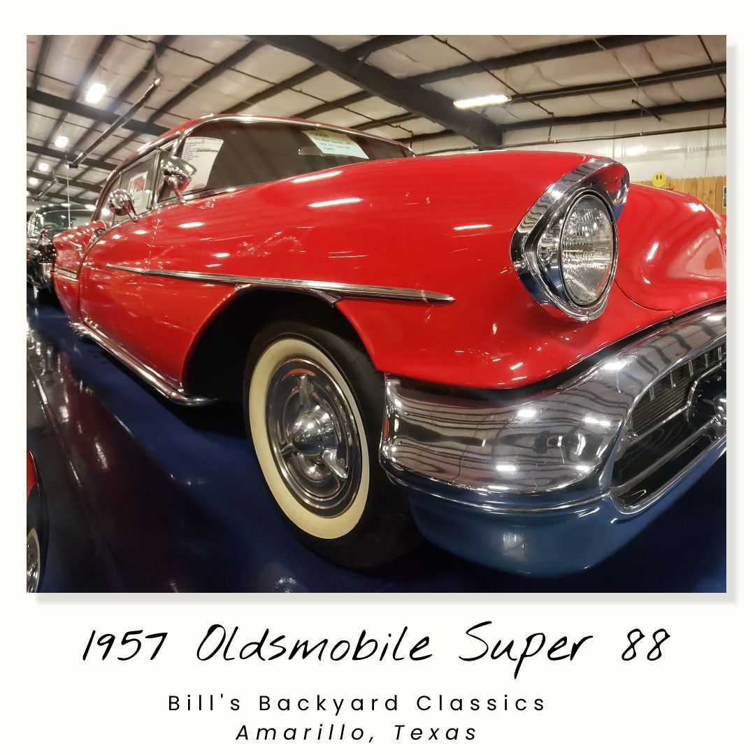 Red 1957 Oldsmobile Super 88 classic car on display, chrome accents, white-wall tires, indoors at a car show in Amarillo, TX.