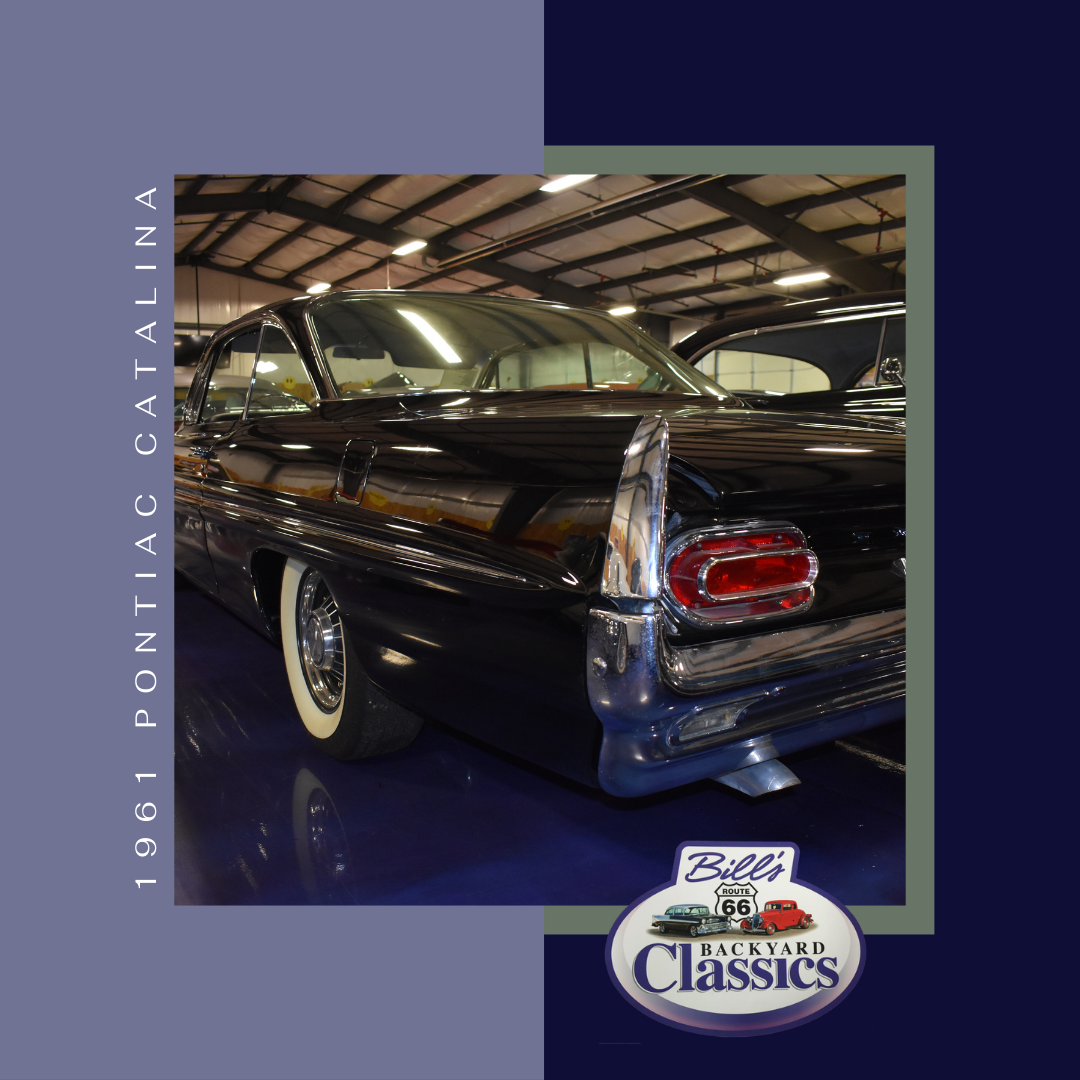 1961 Pontiac Catalina car in a showroom, black with chrome details and whitewall tires.
