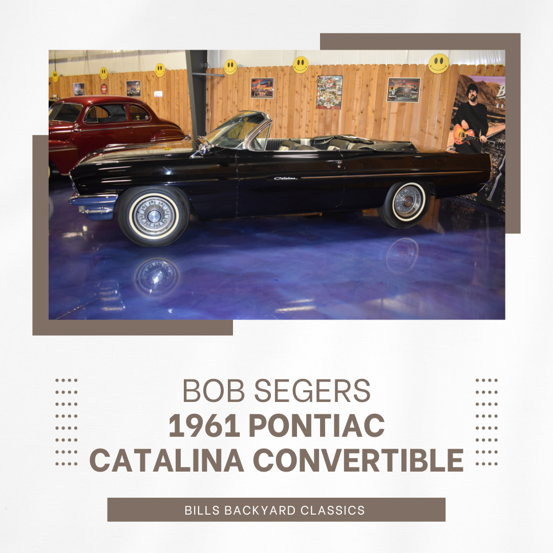 Black 1961 Pontiac Catalina convertible in a showroom with wooden walls and a blue floor.