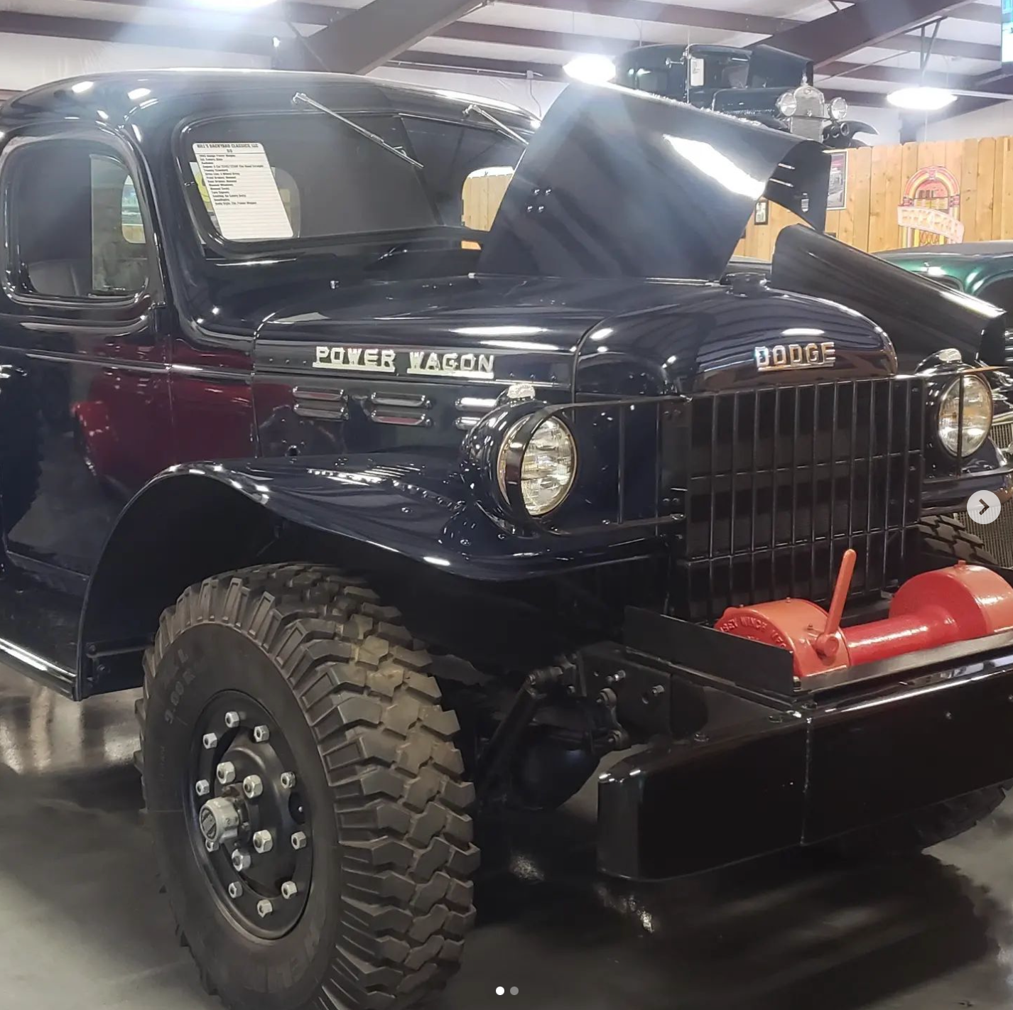 Dark blue vintage Dodge Power Wagon truck with the hood open, parked indoors.