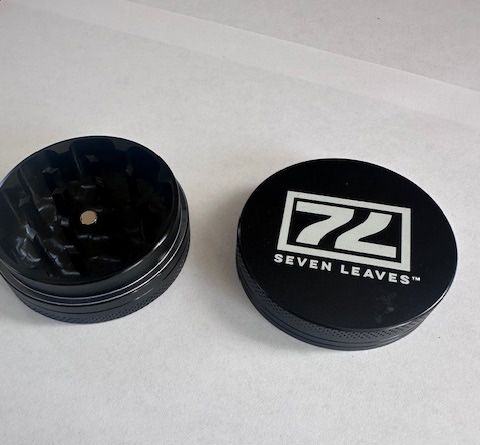 Black grinder with a lid that says 