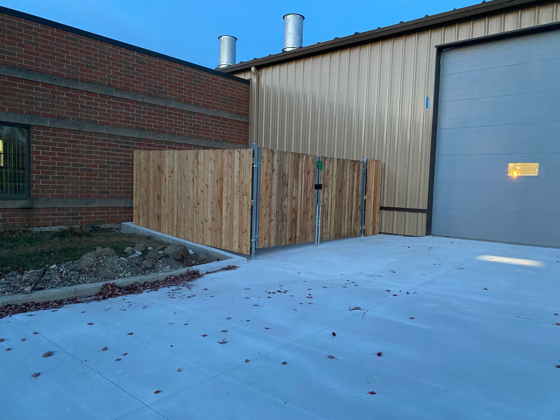A wooden fence is sitting in front of a brick building.