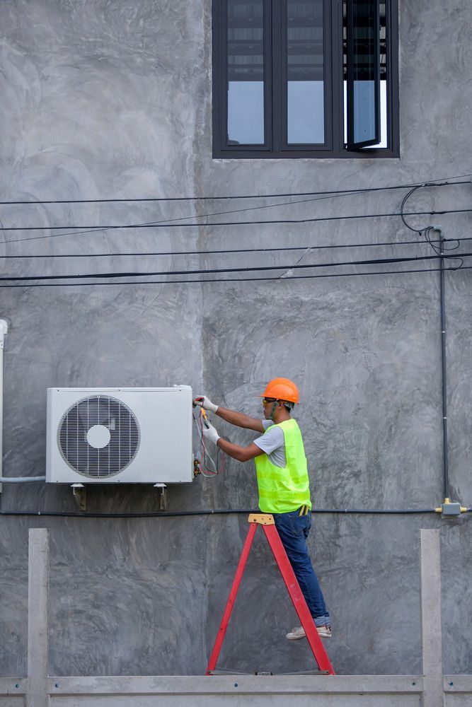Man Installs New Air Conditioner — Cairns & Cape Electrical In Woree, QLD